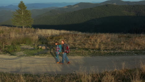 Drones-Turistas-Mochilas-Caminando-Montañas-Camino-Hablando-Contra-Colinas-Verdes