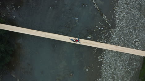 Aerial-mountain-bridge-couple-enjoying-sky-lying-river-relaxing-active-weekend