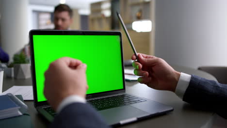 Businessman-hands-researching-computer-laptop-green-screen-on-conference-table.