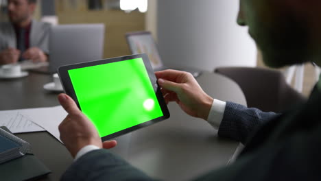 Geschäftsmann-Mit-Tablet-Gerät-Und-Grünem-Bildschirm,-Der-Unternehmensnachrichten-Am-Arbeitsplatz-Betrachtet