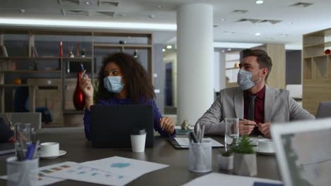 Business-team-wearing-masks-discuss-corporate-strategy-in-coronavirus-pandemic.