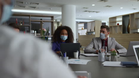 Multiracial-business-group-talk-share-ideas.-Coworkers-wear-covid-safety-masks.