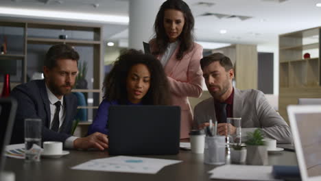 Multiracial-corporate-group-discuss-finance-plan.-Business-team-searching-laptop