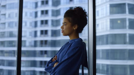 Businesswoman-with-crossed-hands-standing-in-office.Portrait-of-thoughtful-lady