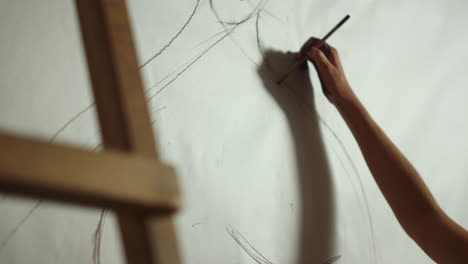 Unknown-female-painter-making-sketch-on-canvas.-Woman-hand-drawing-at-workplace.
