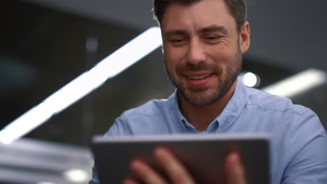 Smiling-executive-video-call-online-conference-using-tablet-device-in-workplace.