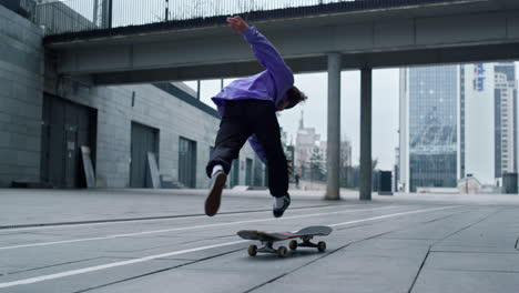 Sporty-skater-making-trick-on-board-outdoor.-Skateboard-rolling-on-asphalt.