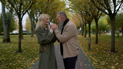 Handsome-bearded-man-kissing-woman-tender-hands-in-autumn-park.-Romantic-couple