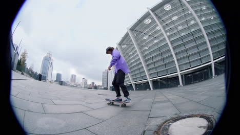 Fisheye-view-of-sporty-skater-guy-balancing-on-skateboard-on-city-street.