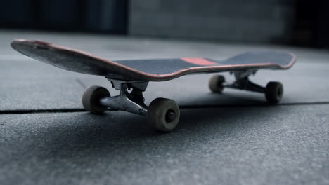 Black-board-with-white-wheels-staying-at-city-street.-Skateboard-for-tricks.