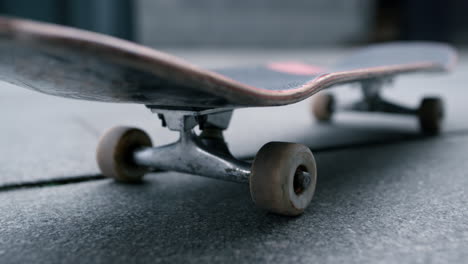 Skateboard-staying-on-sidewalk-in-summer-morning.-Extreme-sports-concept.