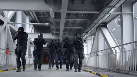 SWAT-Gruppe-Mit-Gewehren-Bewegt-Sich-Auf-Der-Brücke.-Spezialeinheiten-Der-Polizei-Schauen-Sich-Um