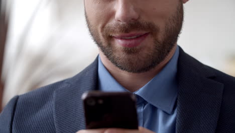 Attractive-businessman-texting-on-cell-phone.-Smiling-man-texting-on-smartphone.