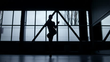 Dancer-silhouette-grinding-dance-steps-indoors.-Athletic-girl-dancing-in-studio.