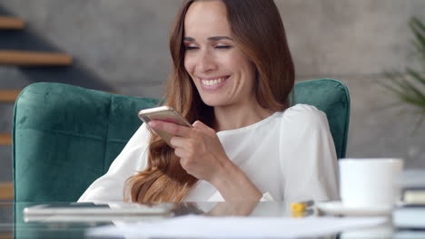 Smiling-business-woman-making-phone-call-in-remote-office.-Girl-using-cellphone.