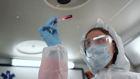 Lab-technician-holding-tube-of-blood-sample.-Scientist-providing-blood-test