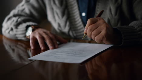 Elderly-man-hands-working-document-at-home.-Old-male-arms-making-marks-contract