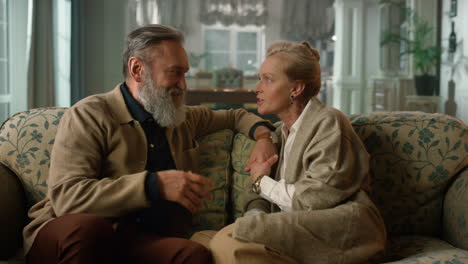 Elegant-old-couple-having-talk-in-classic-living-room.-Senior-family