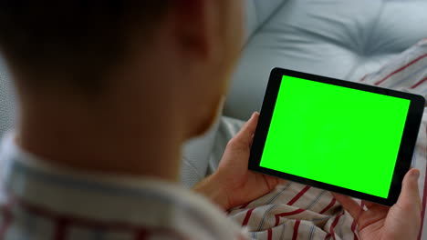 Closeup-hands-holding-chroma-key-tablet.-Unknown-man-typing-green-screen-at-home
