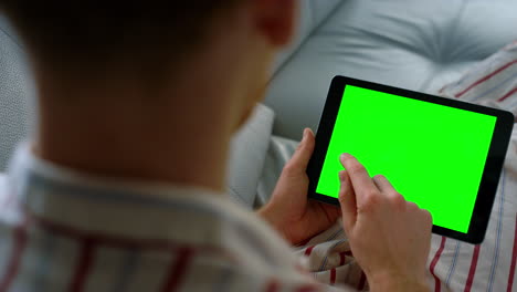 Manager-holding-green-screen-tablet-closeup.-Unknown-man-working-home-remotely.