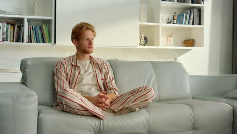 Single-guy-resting-sofa-in-morning.-Pensive-businessman-considering-problems