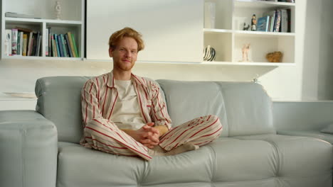 Bachelor-man-enjoy-weekend-at-home.-Joyful-ginger-freelancer-resting-in-pajamas