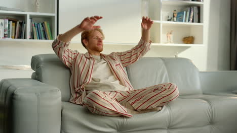 Serene-guy-breathing-air-relaxing-at-cozy-home.-Satisfied-ginger-man-lean-sofa