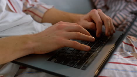 Freelancer-hands-typing-laptop-keyboard-in-pajamas-closeup.-Man-working-late