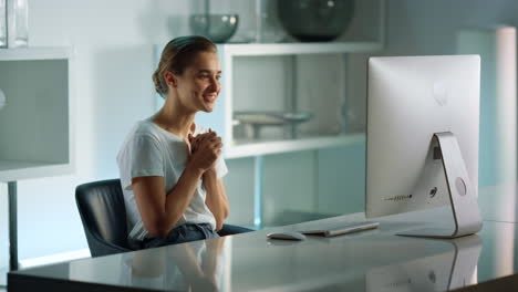 Happy-freelancer-communicating-online-at-home-office.-Joyful-girl-finishing-call