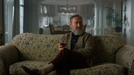 Thoughtful-mature-man-thinking-with-alcohol-glass.-Rich-old-grandfather-relaxing