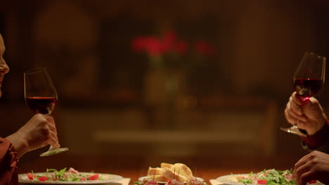 Old-couple-hands-clinking-wine-glasses-romantic-dinner-in-restaurant