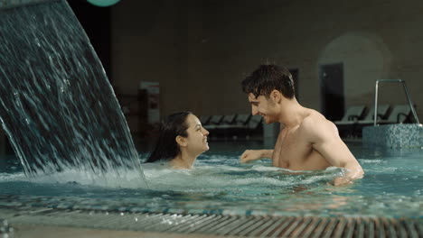 Sensual-couple-hugging-in-spa-pool.-Beautiful-man-and-woman-enjoying-vacation