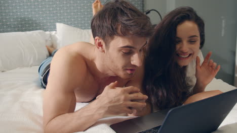 Fancy-couple-talking-laptop-web-camera.-Beautiful-couple-looking-computer-screen