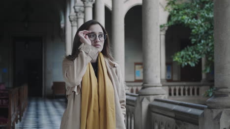 Student-walking-in-colonnade-hallway.Businesswoman-putting-on-eyeglasses-outside