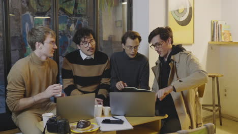 Focused-business-men-discussing-online-project-on-laptop-at-remote-workplace