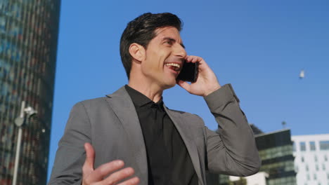 Businessman-talking-mobile-phone-at-street.-Executive-celebrating-success