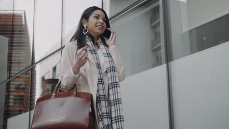 Businesswoman-talking-smartphone-on-street.-Smiling-girl-walking-outdoors