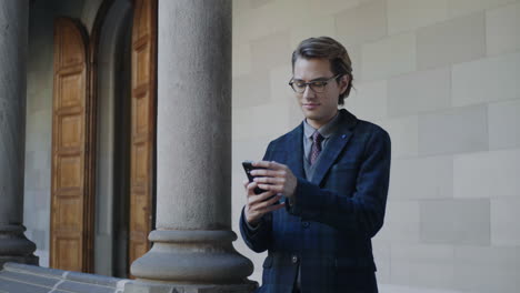 Student-taking-selfie-on-smartphone-in-hallway.-Businessman-using-mobile-phone