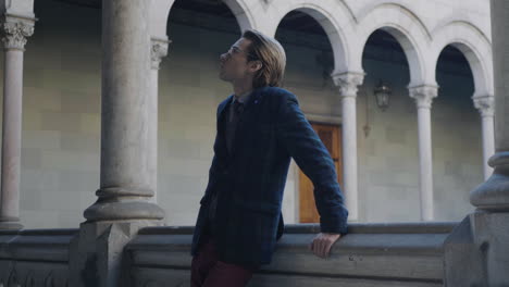 Student-walking-in-college-building.-Man-looking-around-hallway-in-university