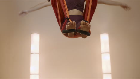 Sportswoman-doing-fly-yoga-at-studio.-Female-gymnast-stretching-body-in-hammock