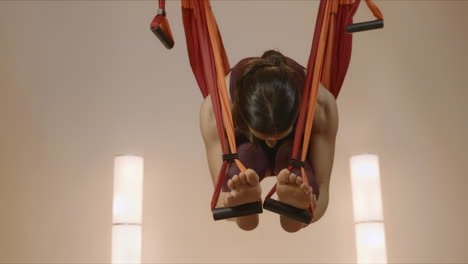 Girl-practicing-antigravity-yoga-at-studio.-Lady-stretching-body-in-hammock