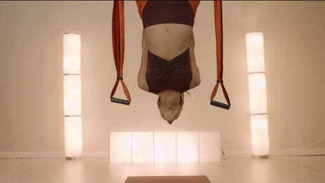 Woman-hanging-upside-down-in-hammock-at-studio.-Girl-practicing-antigravity-yoga