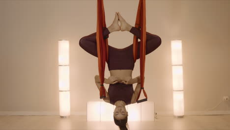 Woman-meditating-upside-down-in-hammock.-Sportswoman-exercising-antigravity-yoga