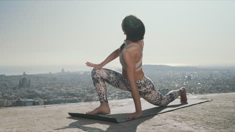 Yoga-Frau-Macht-Verdrehte-Krieger-Pose.-Fitte-Dame,-Die-Ihren-Körper-Im-Freien-Streckt