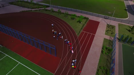 Schoolchild-group-walking-on-sport-ground-in-school-yard-aerial-view