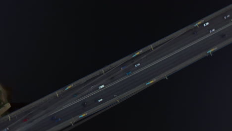 Aerial-view-car-moving-on-river-bridge-in-city.-Car-traffic-on-hanging-bridge