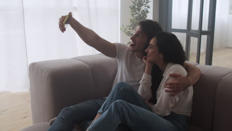 Happy-couple-making-selfie-photo-at-home.-Smiling-man-and-woman-taking-picture