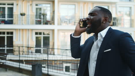 Glücklicher-Afrikanischer-Geschäftsmann,-Der-Draußen-Mit-Telefon-Tanzt.-Gewinner-Afro-Mann-Tanzen