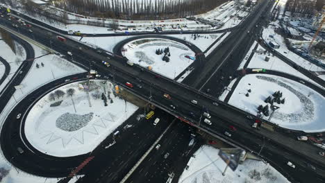 Freeway-intersection-in-winter-city.-Drone-of-car-traffic-on-snowy-road-junction