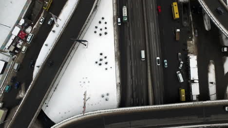 Top-view-car-on-winter-road-in-city.-Aerial-of-road-intersection-in-winter-city
